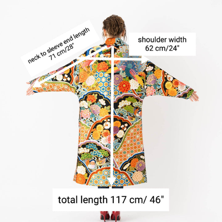 A woman is wearing an oversized silk coat for women. This long silk coat embodies the essence of a long coat for women. Its surface is adorned with intricate silk embroidery, exemplifying the artistry behind a silk embroidered coat for women. The coat's length accentuates its elegance, making it a perfect representation of a long embroidered coat. The oversized nature of this oversized coat for women adds a touch of grandeur to the ensemble, combining style and comfort seamlessly.