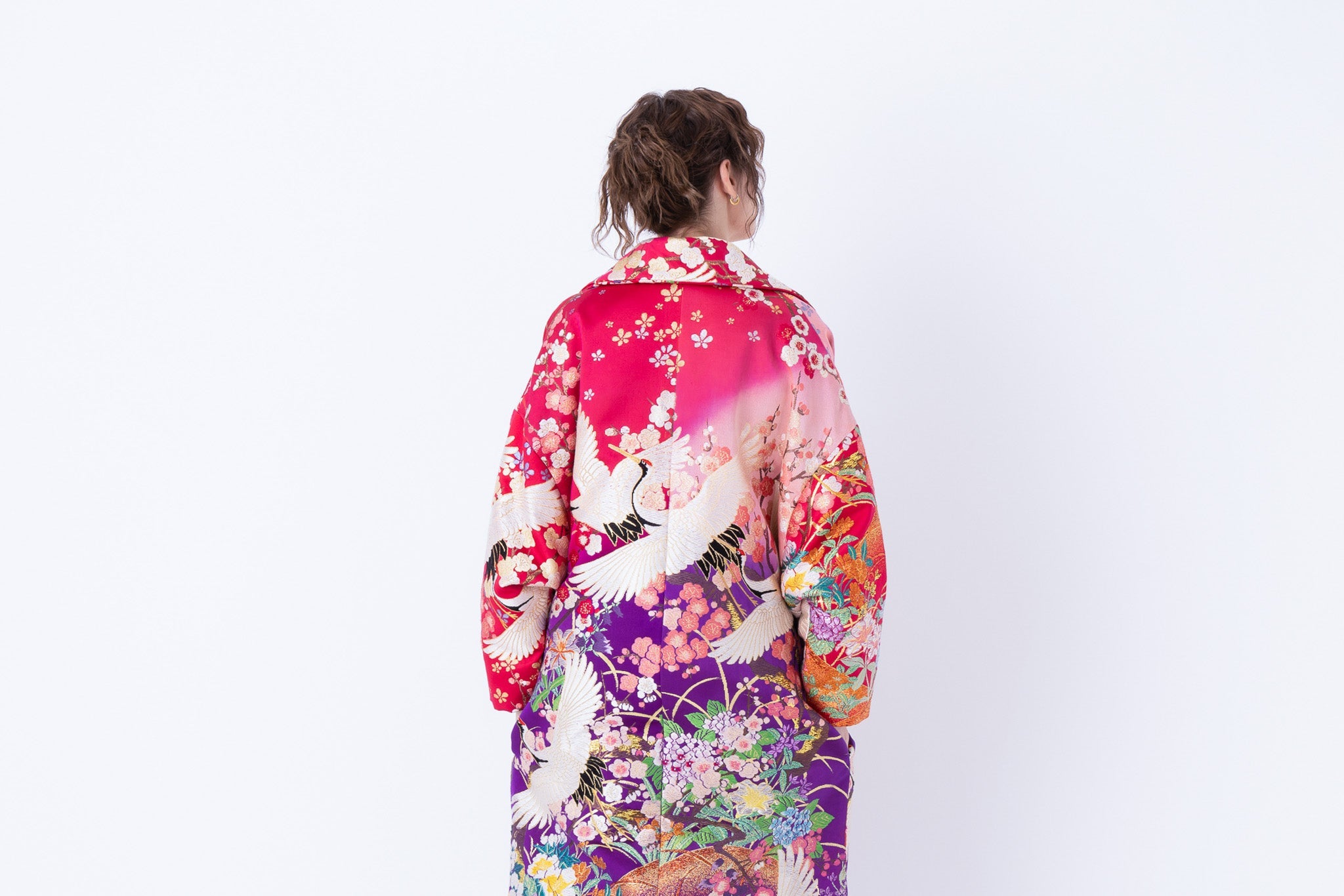 A woman is wearing an oversized silk coat for women, showcasing a unique coat design. This stylish ensemble exemplifies an oversized coat outfit with exquisite embroidery, presenting captivating silk embroidered coat for women.