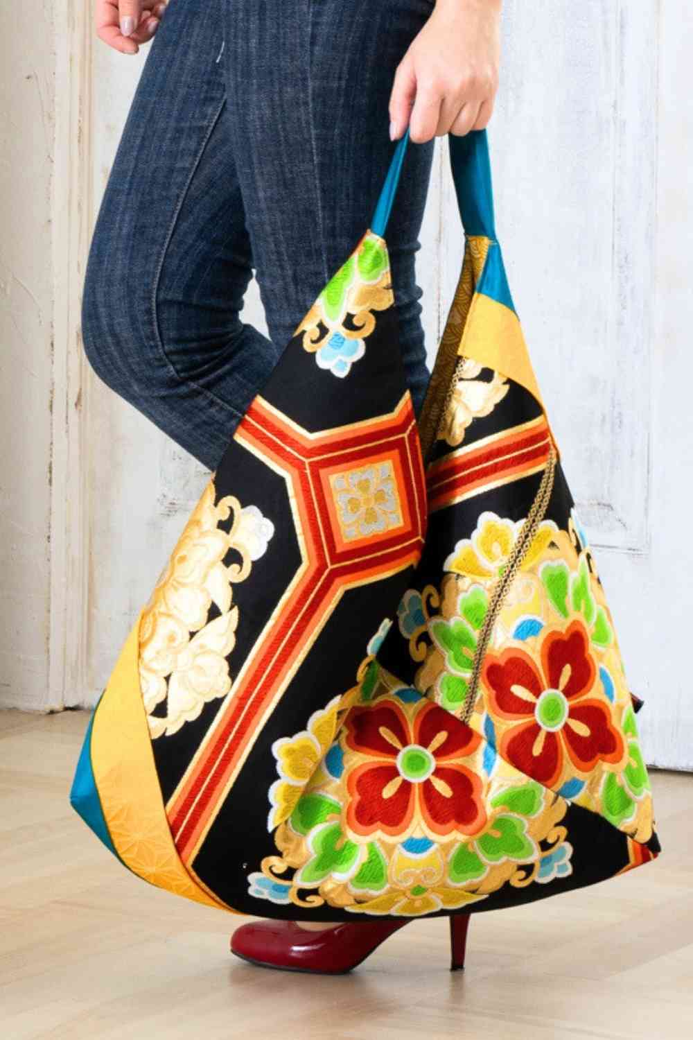 A pictue of a woman carrying a boho bag. With this oversized bag, she is making a bold fashion statement. The intricate details on this embroidered boho bag are a testament to its unique charm and the large boho bag trend. It's a vibrant accessory that elevates her style and captures attention wherever she goes.