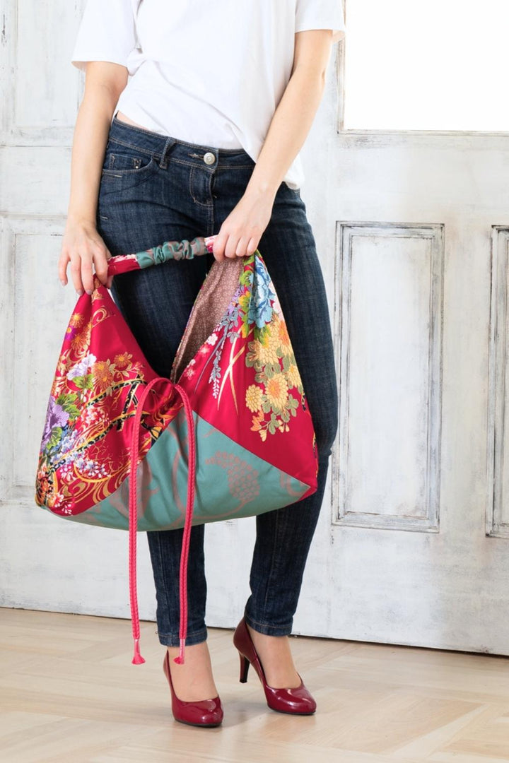 A pictue of a woman carrying a boho bag. With this oversized bag, she is making a bold fashion statement. The intricate details on this embroidered boho bag are a testament to its unique charm and the large boho bag trend. It's a vibrant accessory that elevates her style and captures attention wherever she goes.