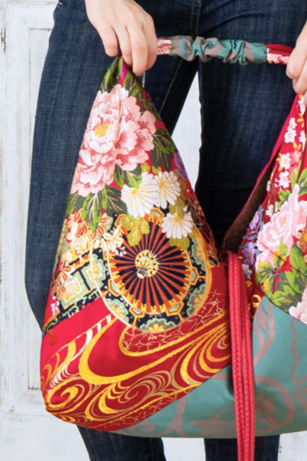 A pictue of a woman carrying a boho bag. With this oversized bag, she is making a bold fashion statement. The intricate details on this embroidered boho bag are a testament to its unique charm and the large boho bag trend. It's a vibrant accessory that elevates her style and captures attention wherever she goes.