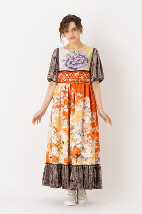 A woman is wearing an empire dress with a classic empire waist, showcasing an empire style dress. This empire waist dress is quite long, making it an example of a high waist maxi dress. This high waist dress enhances her figure. This maxi empire dress exudes sophistication and elegance making it ideal for a formal occasion or a leisurely evening out.