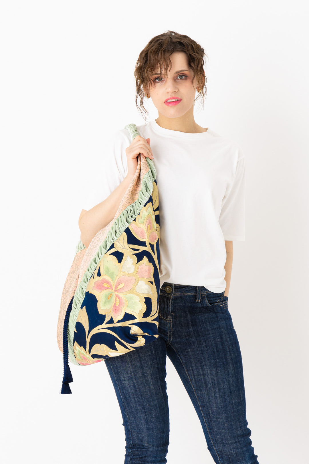 A woman is carrying a stunning embroidered boho bag, showcasing the intricate details on this large tote bag. This large boho bag elevates her style and is an example of embroidered tote bag styling.