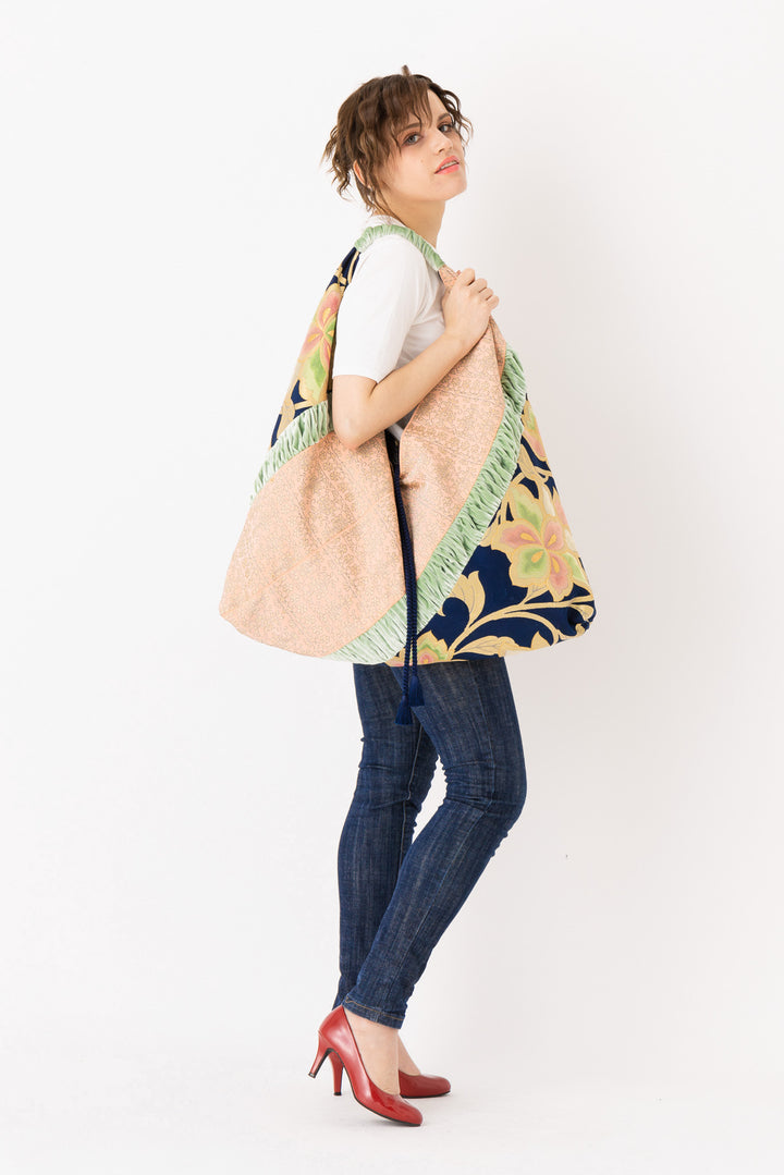 A woman is carrying a stunning embroidered boho bag, showcasing the intricate details on this large tote bag. This large boho bag elevates her style and is an example of embroidered tote bag styling.