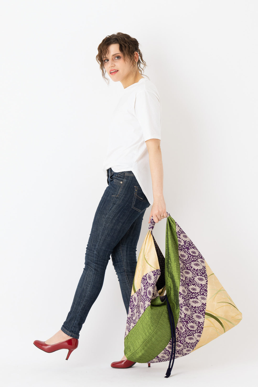 A woman is carrying a stunning embroidered boho bag, showcasing the intricate details on this large tote bag. This large boho bag elevates her style and is an example of embroidered tote bag styling.  