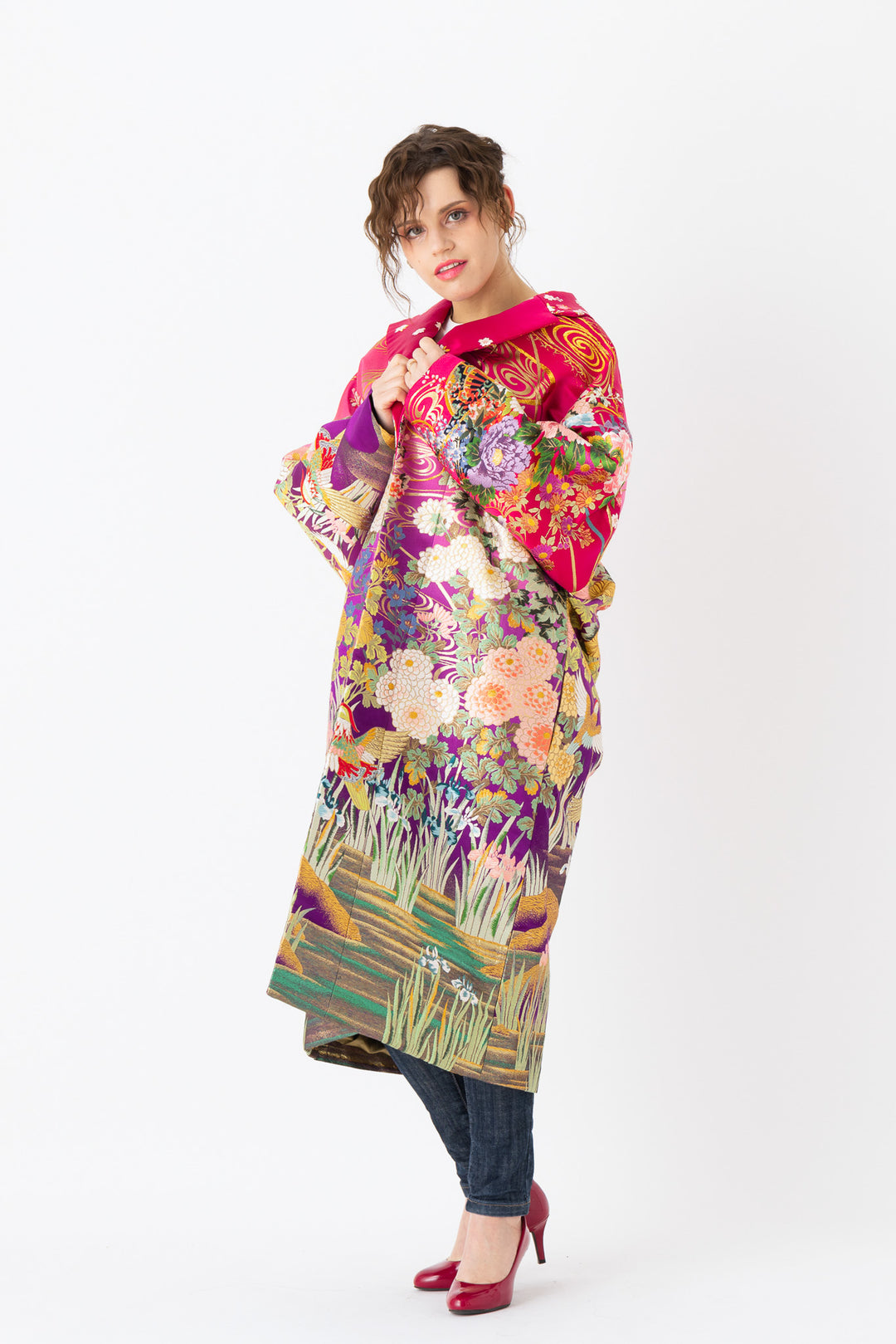 A woman is wearing an oversized silk coat for women. This long silk coat embodies the essence of a long coat for women. Its surface is adorned with intricate silk embroidery, exemplifying the artistry behind a silk embroidered coat for women. The coat's length accentuates its elegance, making it a perfect representation of a long embroidered coat. The oversized nature of this oversized coat for women adds a touch of grandeur to the ensemble, combining style and comfort seamlessly. 