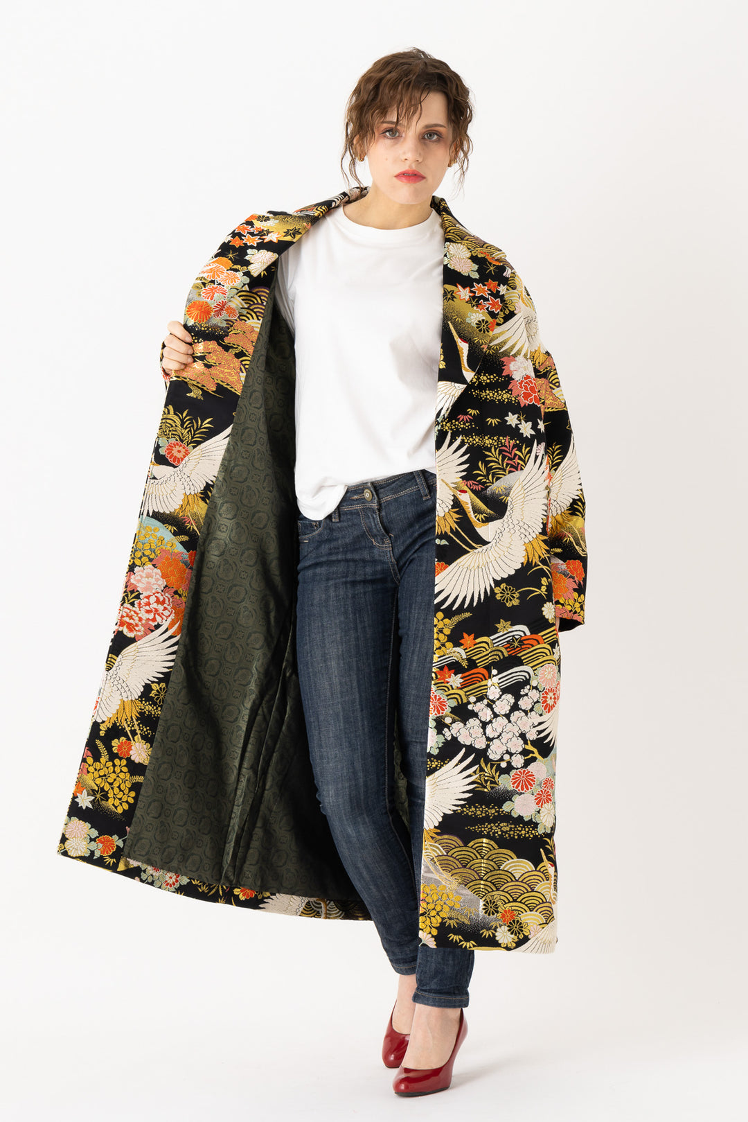 A woman is wearing an oversized silk coat for women. This long silk coat embodies the essence of a long coat for women. Its surface is adorned with intricate silk embroidery, exemplifying the artistry behind a silk embroidered coat for women. The coat's length accentuates its elegance, making it a perfect representation of a long embroidered coat. The oversized nature of this oversized coat for women adds a touch of grandeur to the ensemble, combining style and comfort seamlessly. 